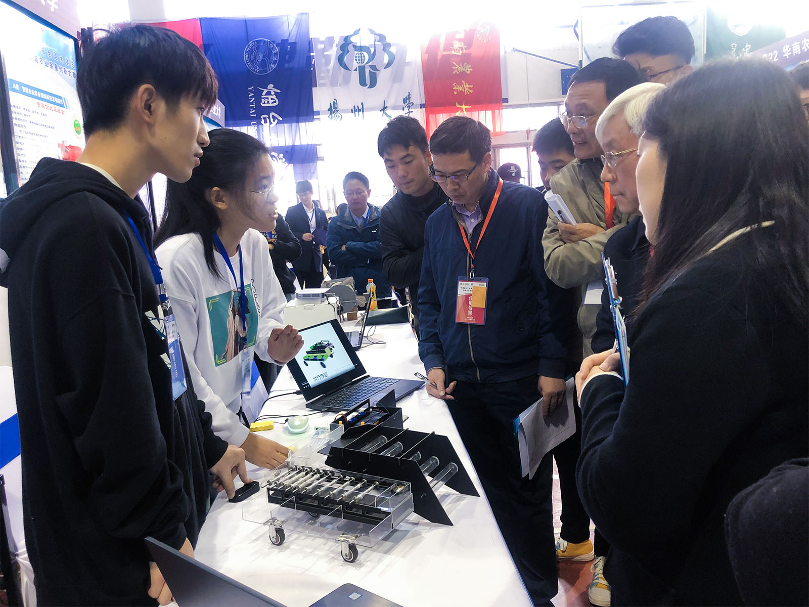 管桐（左一）、田一童（左二 ）同学向专家介绍项目